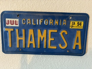A blue and gold California number plate reading THAMES A, with a July tag and a 1994 registration sticker.